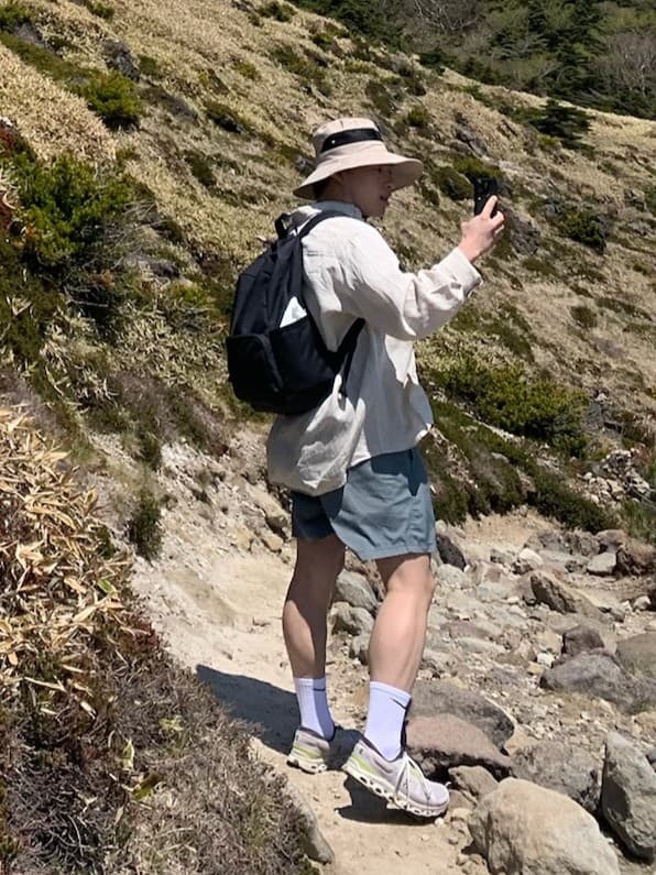 David Cho on a mountain trail, stopping to take a photo